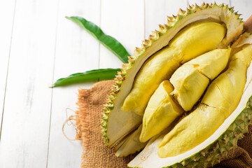 Durian fruit. Ripe monthong durian on sack and white wood background, king of fruit from Thailand on summer