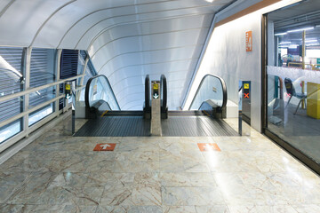 Empty space on marble tile floor and escalator machine. Look clean surface in modern architectural...