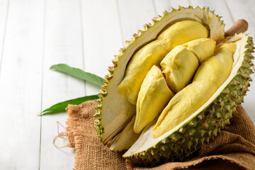 Durian fruit. Ripe monthong durian on sack and white wood background, king of fruit from Thailand on summer