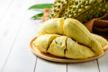 Durian fruit. Ripe monthong durian on sack and white wood background, king of fruit from Thailand on summer