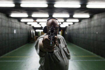 Man aiming with a revolver in an indoor shooting range