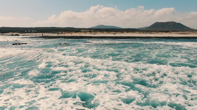 Low drone flight over Playa del Bajo de la Burra (Popcorn Beach), volcanic coastline and Atlantic Ocean, northern Fuerteventura, Canary Islands