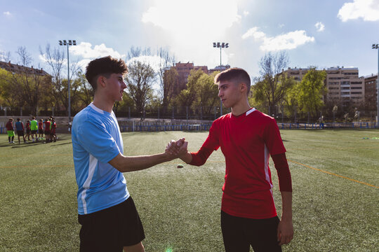 Soccer players wishing luck to each other on field