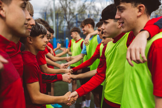 Soccer players shaking hands and congratulating each other on field