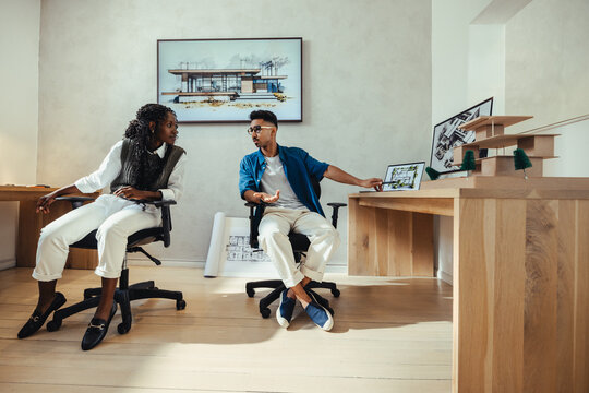 Young architects working on design models and blueprints at a modern office space