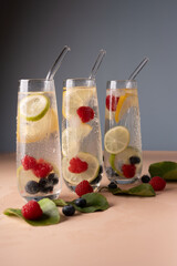 refreshing summer beverage scene with three elegant glasses filled with sparkling water, fresh...