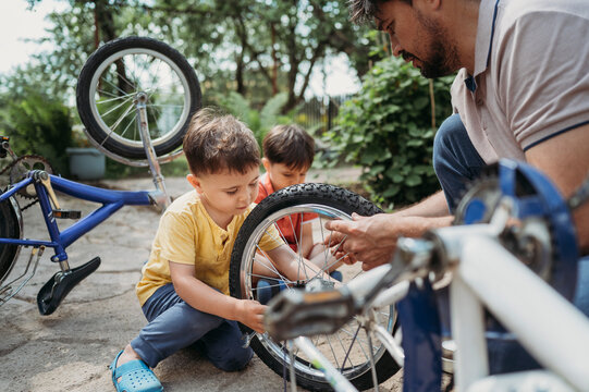 Son helping father in repairing bicycle