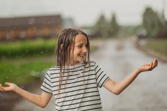 Happy girl with wet hair having fun in rain