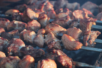 Meat is being grilled on a sunny day