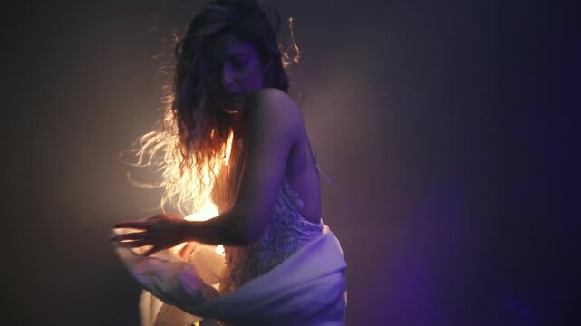 Romantic scene of ballerina in white, glowing backlight creating magical silhouette effect