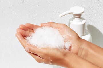 Fototapeta premium A Hands with soap are washed under the tap with water
