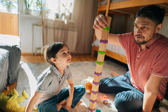 Father and son playing with blocks at home during the day