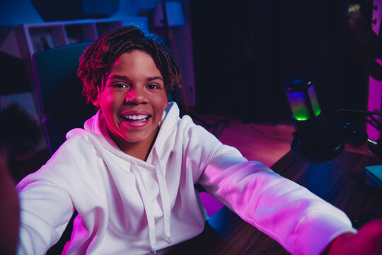 Cheerful Young Gamer and Content Creator Engaged in Streaming with Vibrant Neon Lights