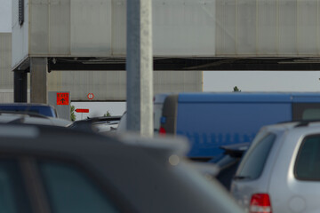 Numerous cars are currently parked within the parking lot located in front of a large building,...