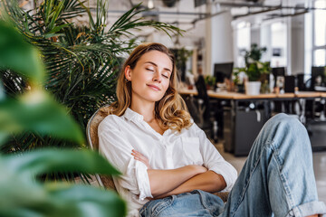 Contemporary young woman taking a break in sustainable office environment