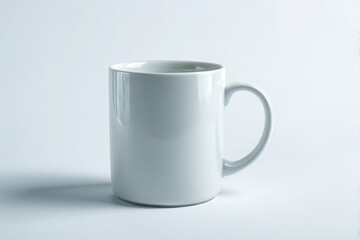 Fototapeta premium A plain white ceramic mug with a handle sits on a clean white background isolated on white background
