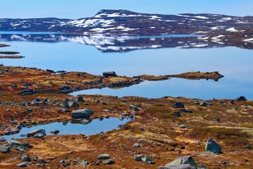Norwegian mountain lake in snowy landscape, scenic route  Hardangervidda