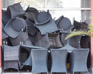 Stacked outdoor chairs near cafe entrance. Concept of storage, furniture, minimalism.