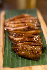 Thai charcoal boiled pork neck served on banana leaf