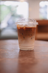 A cup of iced cafe latte with two layer, espresso and fresh milk on wood table