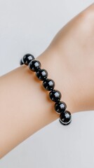 Black Bracelet Elegance: A close-up shot of a wrist adorned with a sleek, black bead bracelet, exuding understated luxury.