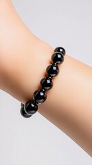 Timeless Elegance: A close-up shot of a wrist adorned with a captivating black beaded bracelet, showcasing sophistication and refinement. 