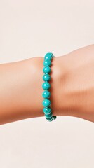 Turquoise Bracelet Elegance: A close-up shot showcases a delicate turquoise beaded bracelet adorning a slender wrist, highlighting its radiant color and intrinsic appeal.