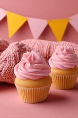 Delicious pink frosted cupcakes on a pastel background.