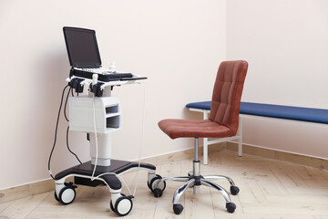 Modern ultrasound machine, chair and examination bed in clinic