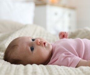 Cute newborn baby lying on bed indoors