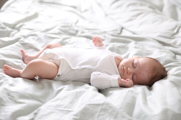 Cute sweet newborn baby sleeping on bed