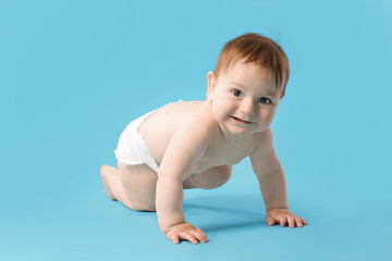 Cute little baby crawling on light blue background