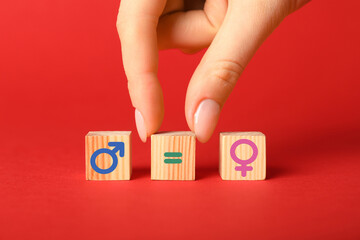 Sex education. Woman putting cube with equals sign between cubes with female and male gender...
