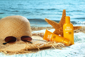 Sun protection. Sunscreens in tube and bottle, hat, sunglasses on beach