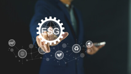 A person in a suit interacts with a digital interface displaying ESG and sustainability icons, symbolizing environmental, social, and governance concepts.