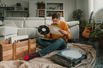 Man examining vinyl disc at home