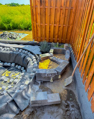 finishing a pond in the garden, surrounded by stones to make a natural pond