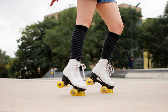 Young woman roller skating on footpath in park