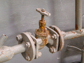 A detailed view of a rusty valve and pipe, showcasing industrial elements and aged metal.