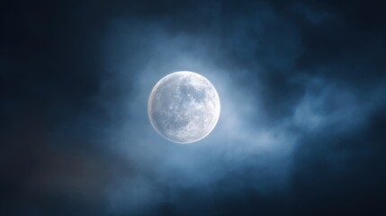 Lunar Majesty: A captivating shot of the moon, suspended serenely in the dark, shrouded with soft, ethereal clouds, is a beautiful depiction of the night sky. Captures a sense of mystery and peace. 