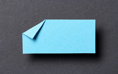 Blue blank paper note cardboard with folded corner dog-ear earmark, shadow and copy space for text...
