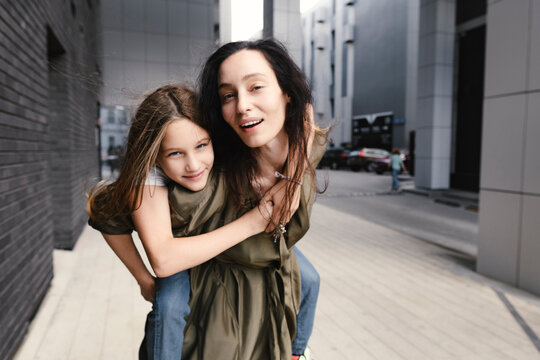 Portrait of mother giving her daughter a piggyback ride
