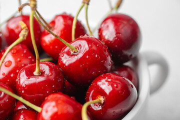Cherries in white bowl on white background for minimal fruit snack or health food concept