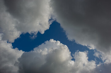 Windows of blue sky in white clouds.