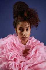 Vertical portrait of young adult multiethnic woman looking into camera wearing dramatic ruffled...