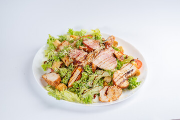 Caesar salad with chicken on a white plate