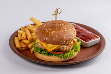 Burger with chicken cutlet, cheese and vegetables in a white bun