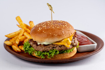 Burger with beef cutlet, cheese and vegetables in a white bun