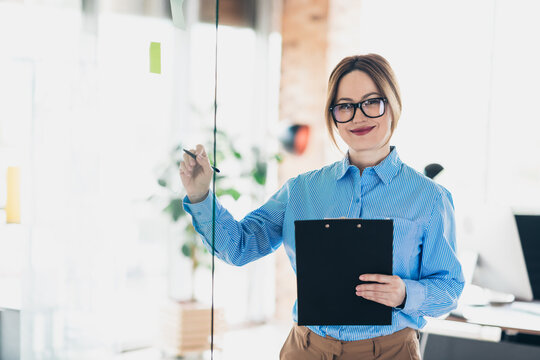 Confident Businesswoman in Office Holding Clipboard During a Successful Presentation