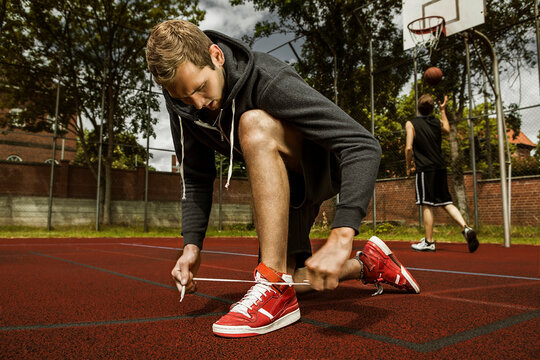 Young basketball player doing up the shoelaces
